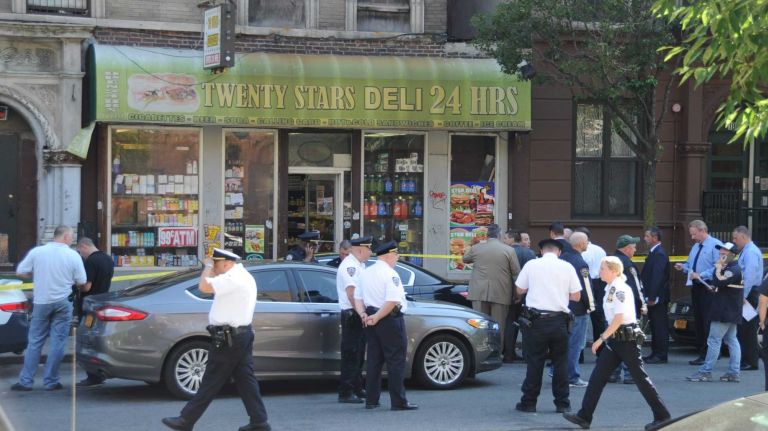 Police officers were on the scene where four people were shot at a bodega in Harlem Wednesday, June 24, 2015.