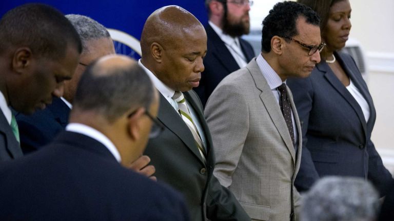 Brooklyn Borough President Eric Adams bows his head and holds hands with others as he kicked off an emergency meeting Thursday, June 18, 2015 at Borough Hall in Brooklyn. The meeting brought together clergy, police and community leaders in the wake of the shootings in Charleston, S.C., that left 9 dead at the Emanuel A.M. E. Church there last night. The meeting was intended to prepare attendees to deal with similar situations if they might happen in their respective houses of worship.