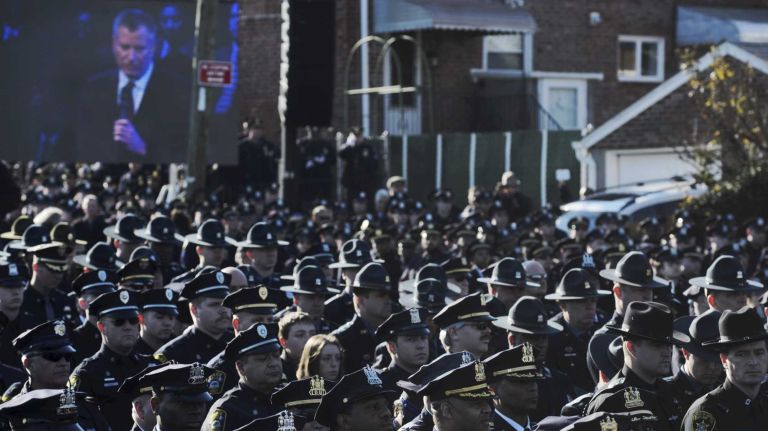 Officers turn backs on NYC Mayor Bill de Blasio during eulogy for slain cop Rafael Ramos 2 Police officers outside the church turn their backs as New York City Mayor Bill de Blasio's eulogy for slain Officer Rafael Ramos is televised on Saturday, Dec. 27, 2014.