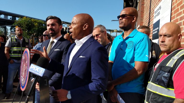 Asbestos in Brooklyn bus depot sickened workers, merits remediation: TWU Local 100 2 Councilmember Rafael Espinal, left, Brooklyn Borough President Eric Adams, at podium, and TWU Local 100 Secretary-Treasurer Earl Philips, right, hold a press conference on Wednesday, Sept. 25.