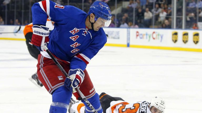 Rick Nash of the New York Rangers plays the puck in the third period against Shayne Gostisbehere of the Philadelphia Flyers at Madison Square Garden on Monday, Sept. 29, 2014 in New York City.