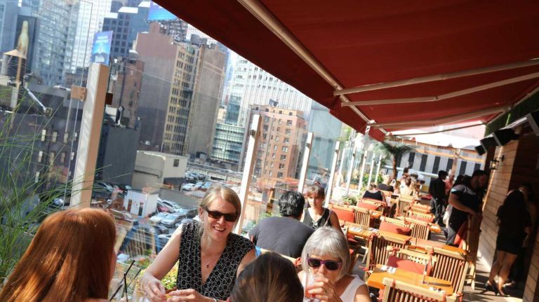 People sip drinks at The Haven Rooftop at 132 W. 47th St. in the Theater District.
