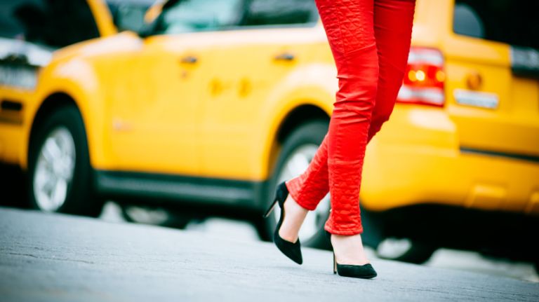 A woman in front of a cab.