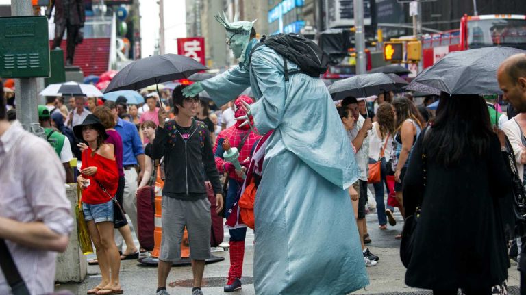 Times Square costumed characters look to form group amid crackdown 1 A Statue of Liberty and Spider Man character, a fixture on Times Square, work during a rain shower Tuesday, August 12, 2014.