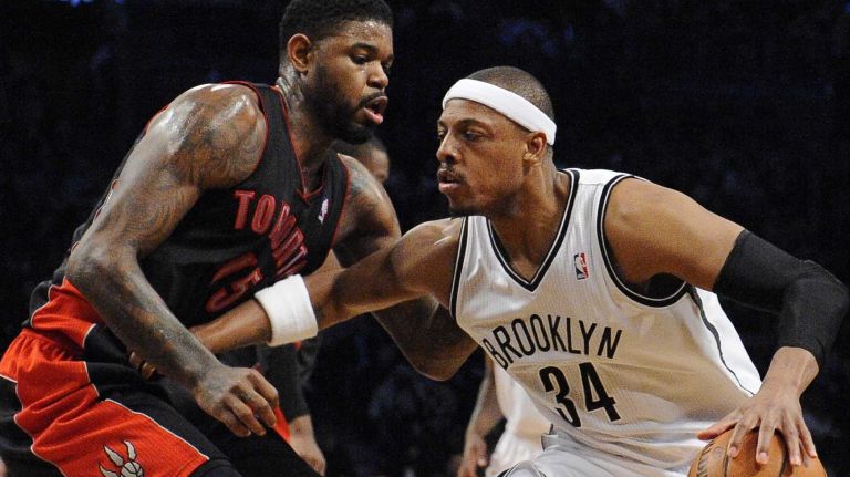 Nets forward Paul Pierce is defended by Toronto Raptors forward Amir Johnson in the first half of an NBA basketball game at Barclays Center on Monday, March 10, 2014.