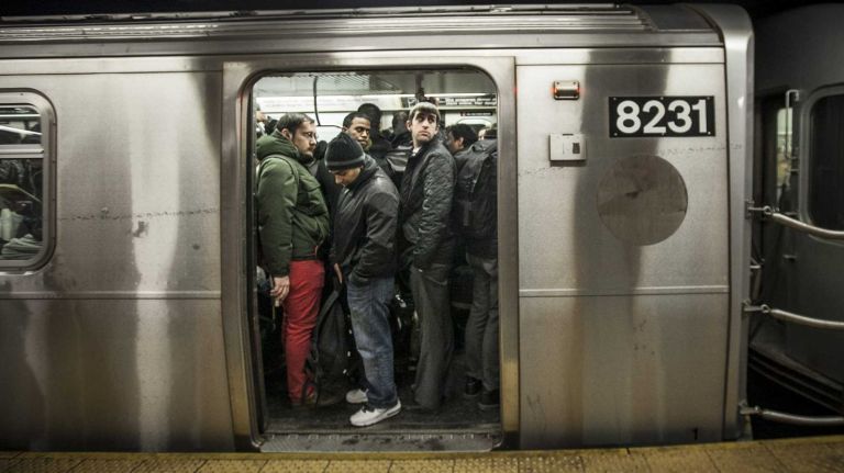 Straphangers pack into a crowded car in the Union Square subway station in Manhattan on March 20, 2014.