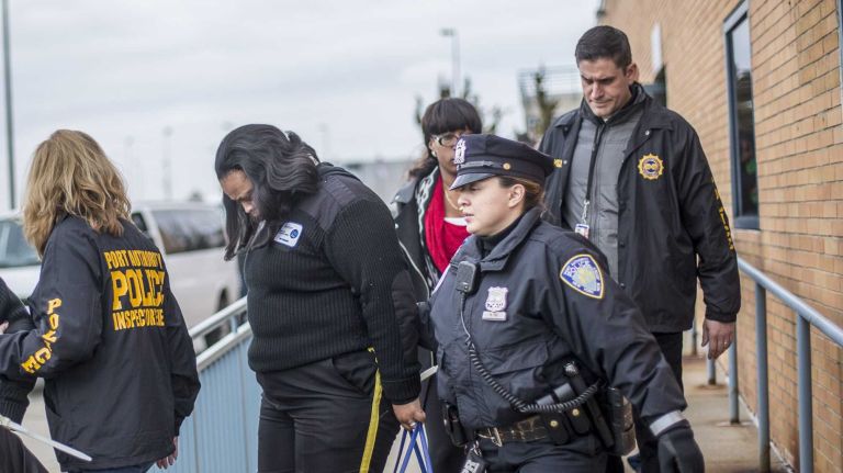 JFK Airport taxi dispatchers are led to law enforcement vans after being arrested in a bribery sting on Wednesday, March 19, 2014. 