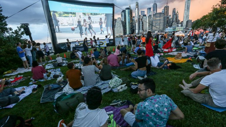 Visitors relax on the lawn at Pier 1 as they wait for the movie to begin at the Brooklyn Bridge Park's Movie With a View series on Aug. 8.