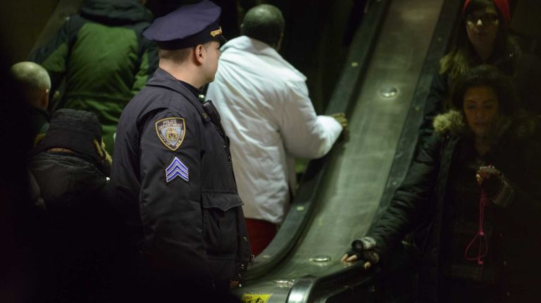 Robberies in transit system fell last year 1 An NYPD officer watches passengers as they arrive at Grand Central Station on Monday, Jan. 27, 2014.