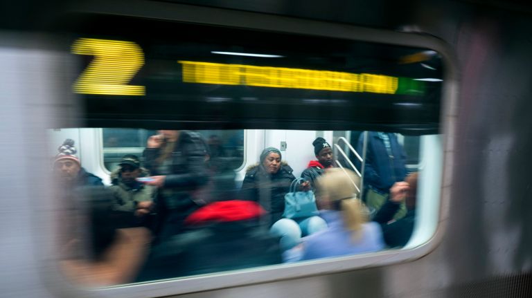 People are seen though the window of an MTA subway 2 train as it pulls out the Times Square subway station Friday, Dec. 1, 2017.