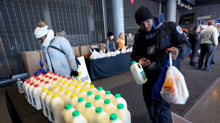 Furloughed federal workers receive food and supplies from the Food Bank for New York City at a pop-up distribution event at the Barclays Center in Brooklyn on Tuesday.