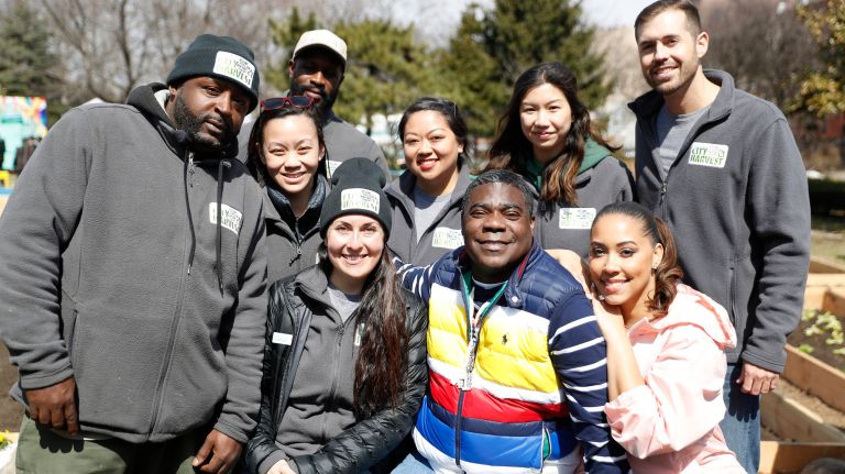 Tracy Morgan and his wife, Megan Wollover take a group picture City Harvest's employees at&nbsp;the Hattie Carthan Community Garden.
