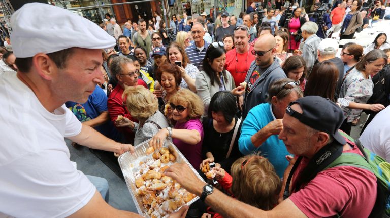 Danny Fratta gives out leftover zeppoles at the San Gennaro Festival in Little Italy.