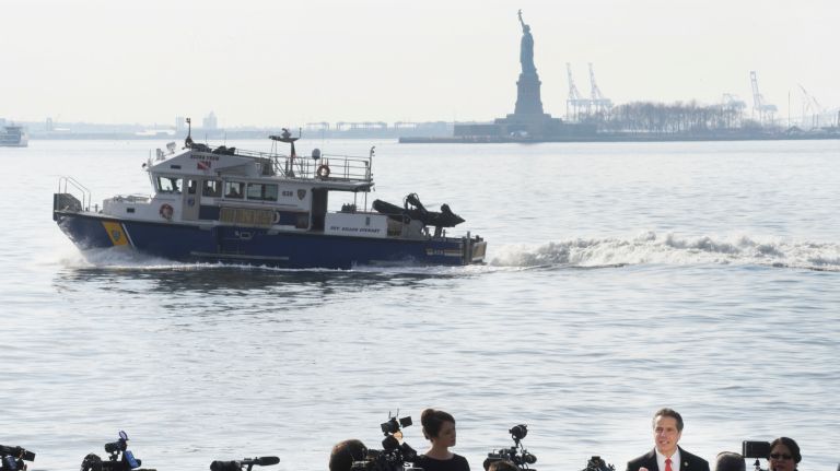 A New York Police Department boat passes as New York State Andrew Cuomo announces that New York State money will be used to reopen the Statue of Liberty during press conference across the harbor from the statue in Wagner Park in lower Manhattan, Sunday, Jan. 21, 2018. Both the Statue of Liberty and Ellis Island have closed to visitors since the most recent federal government shutdown.