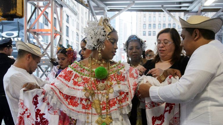 Participants in the 53rd annual Hispanic Day Parade seek shelter from the rain before the festivities begin along Fifth Avenue in  Manhattan  on Sunday, Oct. 8, 2017.