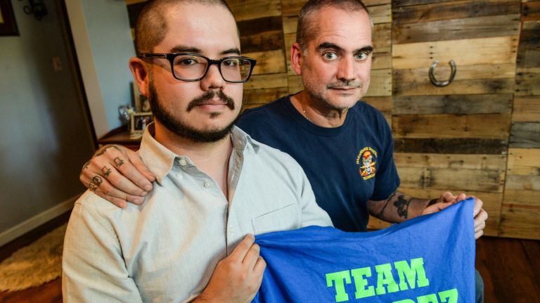David Alvarez, left, with his father Lou, a retired NYPD officer with 9/11 related cancer, sit in their Oceanside  living room, Wednesday, July 5, 2017.
