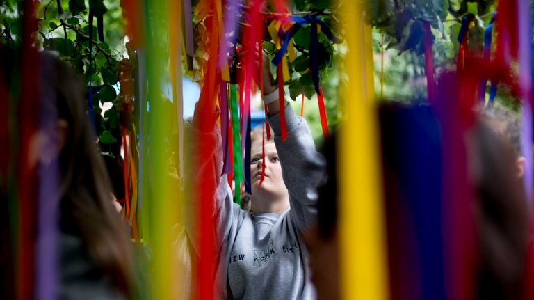 People place rainbow-colored ribbons on the Survivor Tree at a memorial service for the victims of the mass shooting at the Pulse  nightclub in Orlando, Fla.  at the World Trade Center Memorial in lower Manhattan  on Thursday, June 16, 2016.