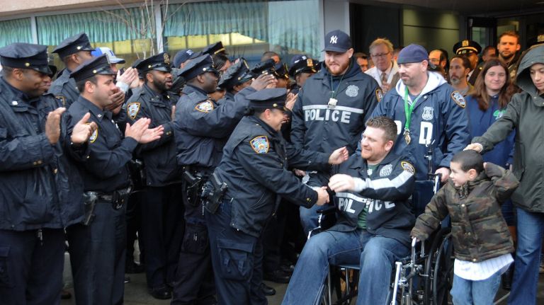 NYPD officer William Reddin of Lynbrook leaves Kings County Hospital in Brooklyn on Feb. 23, 2016. Behind him in Yankees cap is his partner, Andrew Yurkiw of Wantagh, who was also injured. 
