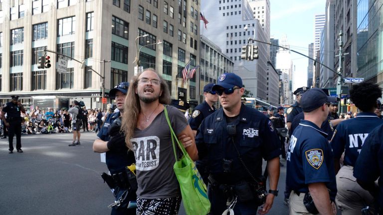 A man is seen getting arrested at the protest in midtown. He was one of 48 people arrested, police said.