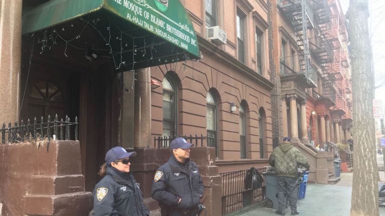 In response to the New Zealand mosque attacks, NYPD officers stand guard outside the Mosque of Islamic Brotherhood on St. Nicholas Avenue in Harlem on Friday.