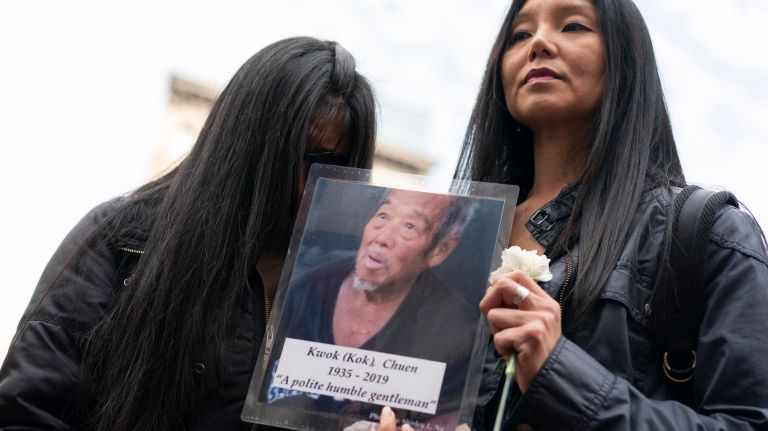 Shirley Ng, right, holds a picture she took of Chuen Kwok, 83, one of the victims, during a vigil in Kimlau Square in response to the killings&nbsp;of four homeless men in Chinatown. &nbsp;