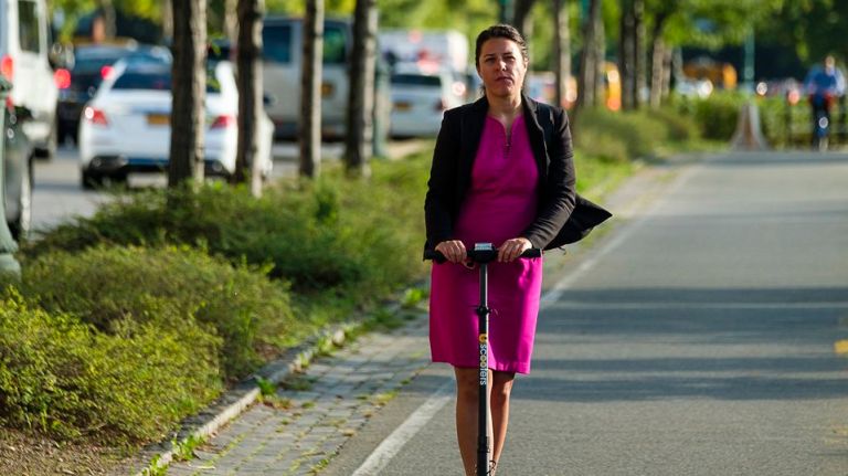 A woman rides an E-Scooter on the Hudson River Greenway bike path on Wednesday.