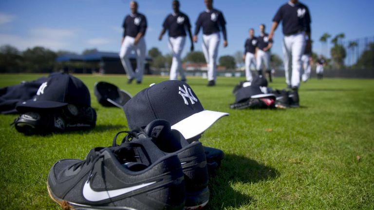 Equipment sits in the grass of Steinbrenner Field as the Yankees warm up during spring training, Feb. 15, 2014.