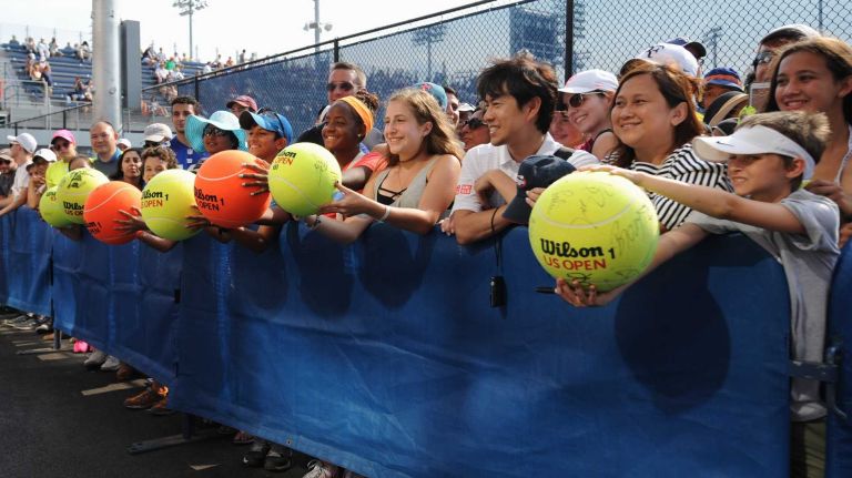 Fans wait by the practice courts for player autographs during the first round of the U.S. Open on Monday, Aug. 31, 2015.