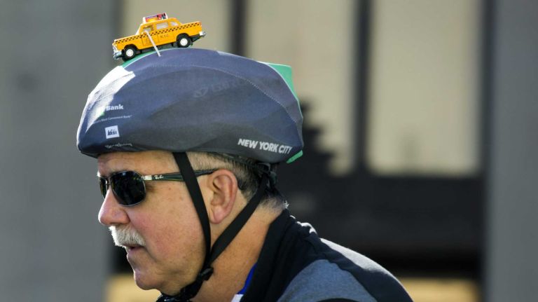 A participant a helmet adorned with a taxi cab as the Five Boro Bike Tour starts in Soho Sunday, May 3, 2015.