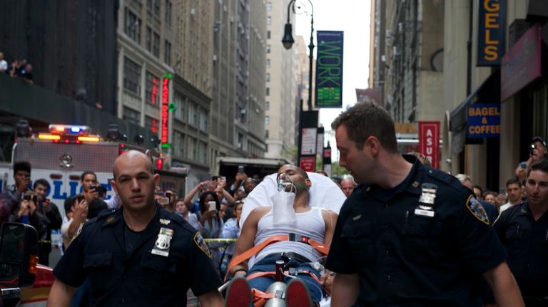 Police escort the suspect in an alleged hotel burglary into an ambulance after he passed out during his arrest on Tuesday, Sept. 30, 2014. 