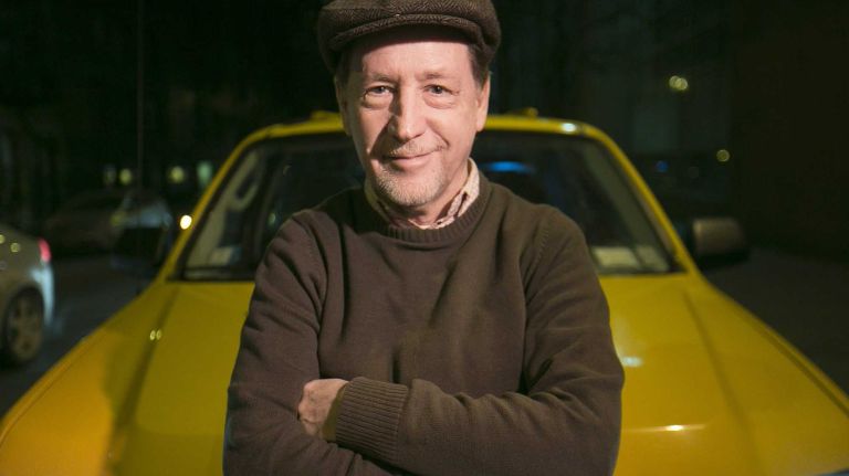 New York City cabbie Eugene Salomon poses for a photo by his taxi cab, before his shift, on Jan. 28, 2014.
