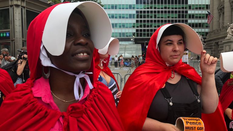 Protesters in ‘Handmaid’s Tale’ costumes rally outside Manhattan DHS Cybersecurity Summit 1 Statue of Liberty climber Therese Patricia Okoumou, left, took part in a