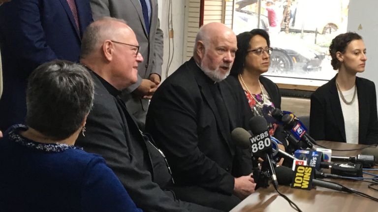 With dozens of immigrant children in their care who were separated from their families, Cardinal Timothy Dolan, left, and Msgr. Kevin Sullivan, center, the head of Catholic Charities New York, give an update on the children's status on Thursday.