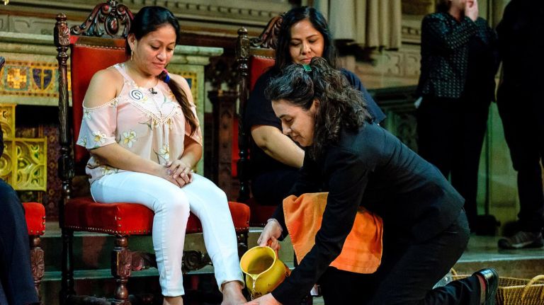 A member of the clergy washes Aura Hernandez's feet at the Fourth Universalist Society. 
