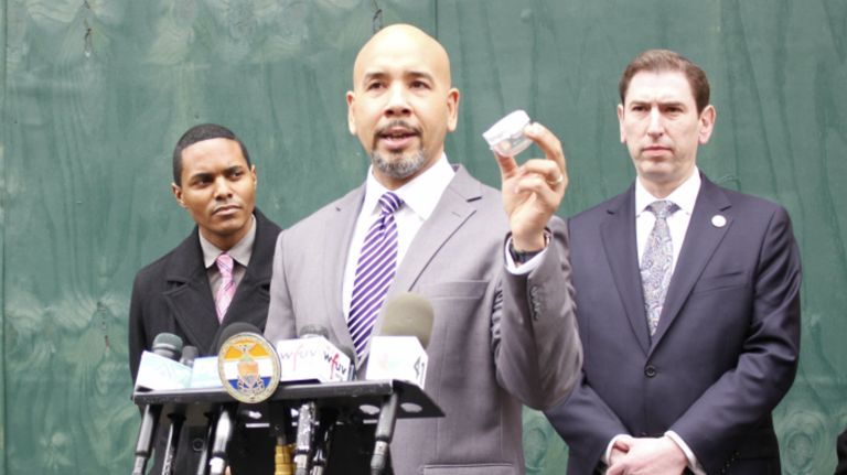 Bronx borough President Ruben Diaz Jr., center, holds a sample safety knob that his proposed legislation would mandate for apartments with children who are 10 and younger  in front of the site of the Prospect Avenue fire in Belmont on February 15, 2018. He is joined by Councilmen Ritchie Torres, left, and Chaim Deutsch. 