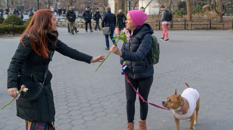For International Women's Day on Friday, Noelle Lauren Contey, left, handed&nbsp;out flowers with inspiring quotes on them&nbsp;in Washington Square Park.