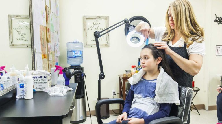 Melissa Levin of Dix Hills, owner of Lice Tamers, screens Nicole Gellers hair for lice at Lice Tamers in Melville, March 24, 2015.