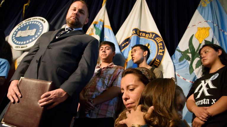 New York City Council Speaker Corey Johnson, left, looks as Sandra Chica, second from right, holds her daughter, Luciana, during a news conference Monday at City Hall a day before her husband's immigration hearing. Pablo Villavicencio was detained by Immigration and Customs Enforcement while delivering pizza at Fort Hamilton, a U.S. military base.