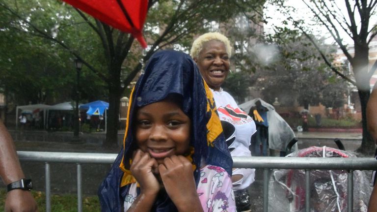 A young spectator tries to stay dry during the&nbsp;West Indian American Day Parade in Crown Heights on Monday.