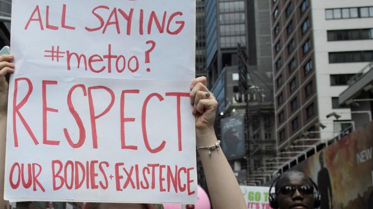 An activist holds a sign as she marches topless to get a message across.