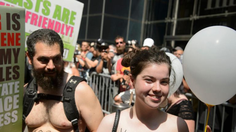 A Topless.org participant and supporter march.