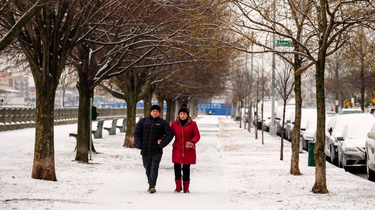 NYC weather: Snow, followed by coldest day of the season expected in city 2 A couple stroll on the snow-covered promenade on Shore Boulevard in Manhattan Beach, Brooklyn, on Friday.