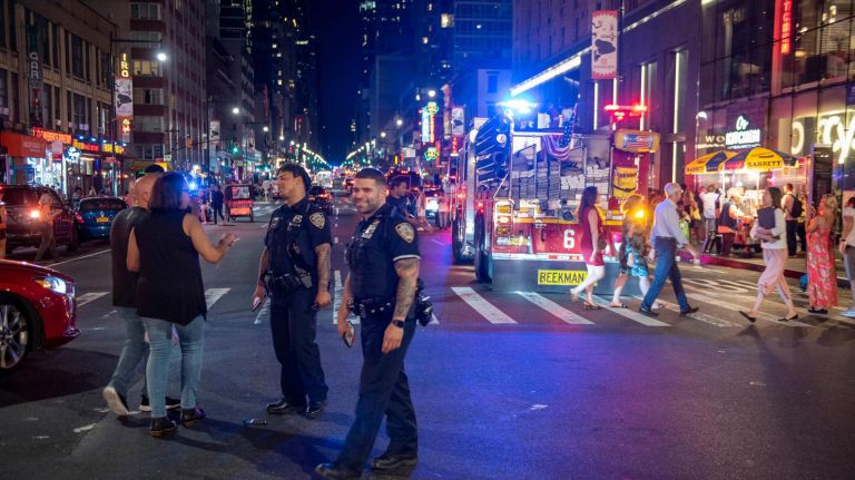 Smiling police officers at moment the lights returned. Power in midtown and upper westside Manhattan.