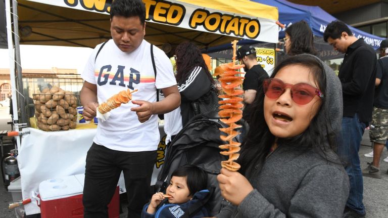 The Bronx Night Market began its second season with a bang as thousands flocked to try the variety of food and drink at the Fordham Plaza site in the Bronx. Lucy Garcia, 7, gets ready to eat twisted fries, as her dad Gustavo and brother Alex, 1, eat too.