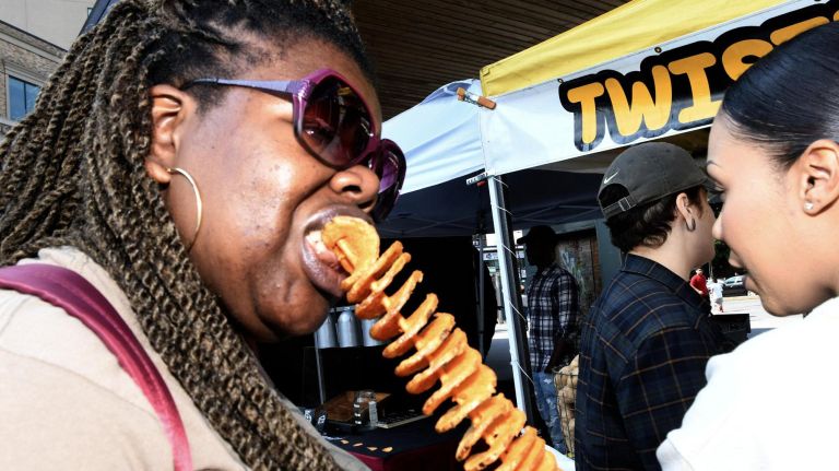 Chiaka John, 30, of Flatbush, Brooklyn, enjoys a twisted potato at The Bronx Night Market. The market began its second season with a bang as thousands flocked to try the variety of food and drink at the Fordham Plaza site in the Bronx.