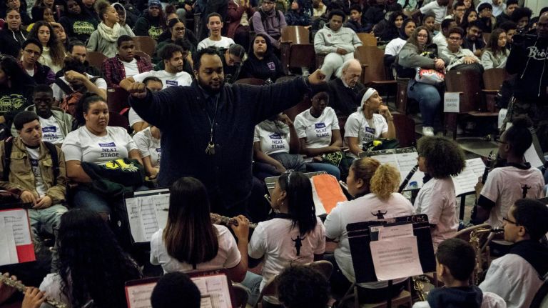 Steven Oquendo, the music director of at Pelham Prep in the Bronx, composes during the school's pep rally on Thursday.&nbsp;