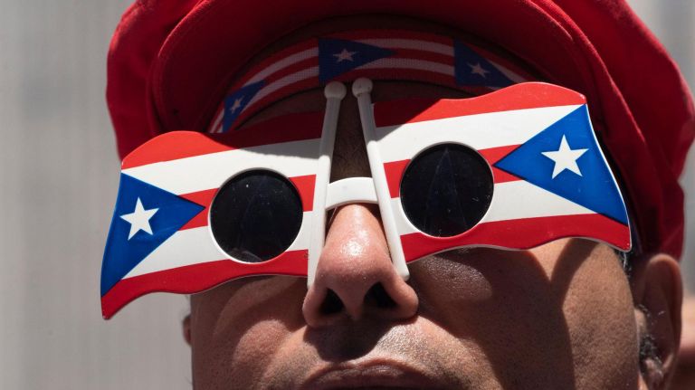 A person wears oversized sunglasses with a frame in the shape of Puerto Rican flags during the 2019 Puerto Rican Day Parade, Sunday, June 9, 2019. The parade is in its 62nd year and is celebrating the creativity and diversity of thought in Puerto Rico and across the diaspora, according to the parade organizers.