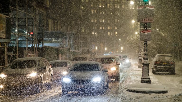 Drivers traverse snow-covered Park Row near City Hall in Manhattan on Nov. 15, 2018.