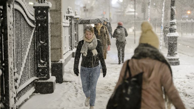 People walk along snowy Park Row near City Hall in Manhattan on Nov. 15, 2018.