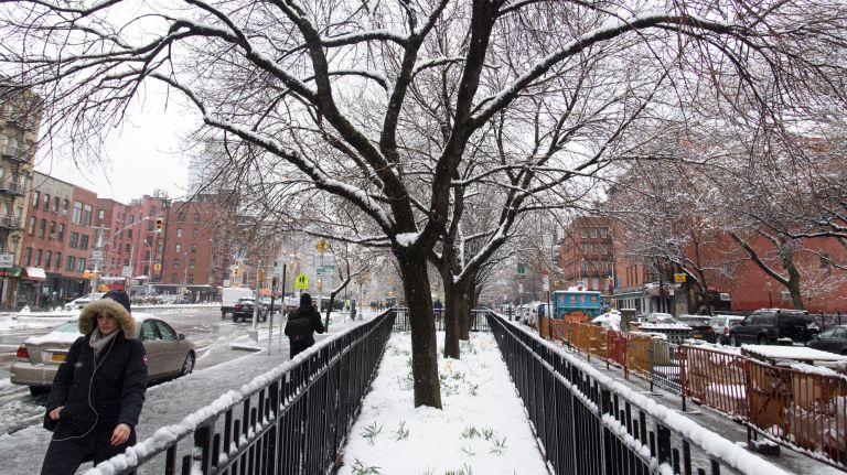 People walk along Houston Street in Manhattan during a spring snow on April 2, 2018.
